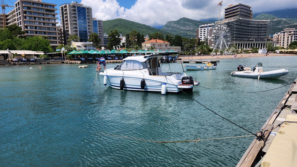 Antares 606 moored in Budva Marina with waterfront buildings behind.