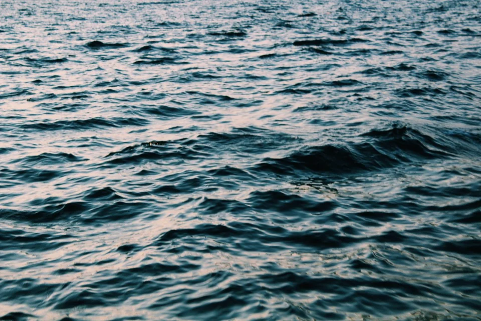 Small blue-green waves with bands of reflected light.