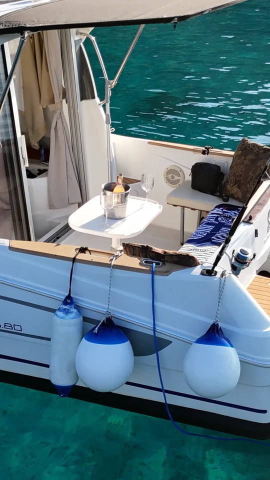 The shaded stern seating area of Antares 606 above turquoise water.