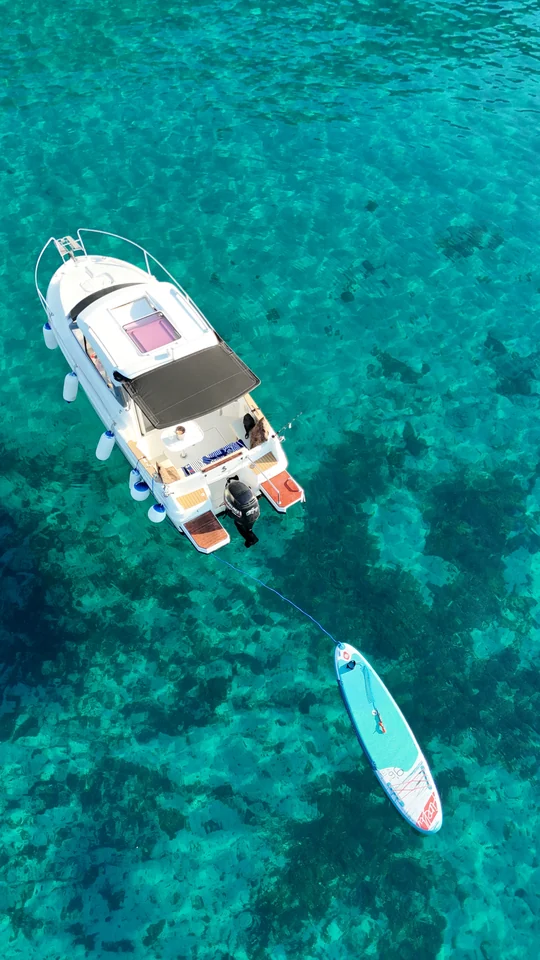 Aerial view of Antares 606 with a paddleboard floating behind the stern.